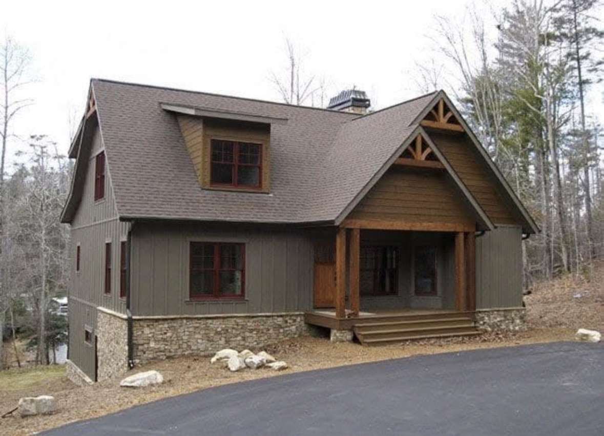 Mountain home exterior painted deep olive with stained timber porch posts